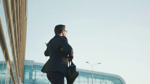 Businessman doing crazy, funny moves while standing outdoors near office Stock Footage 76636186