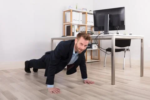 Businessman Doing Exercise In Office Stock Photos