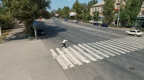 Businessman Doing flips and tricks across the road in city. Aerial footage. Stock Footage 67343411