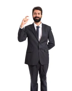 Businessman doing tiny sign over white background Stock Photos