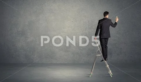 Businessman drawing on grunge wall Stock Photos