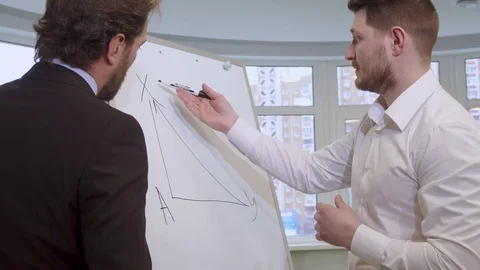 Businessman draws on the flip chart Video stock 71411459