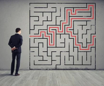 Businessman draws the solution of a labyrinth. Concept of problem solving Stock Photos