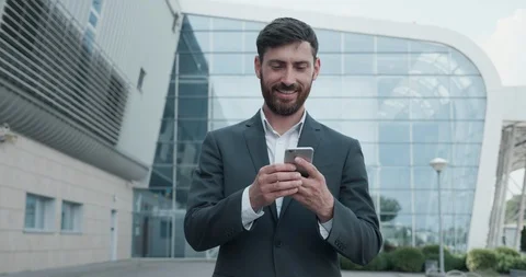 A BusinessMan Dressed in grey Typing Message on Mobile Phone. Video stock 123459696