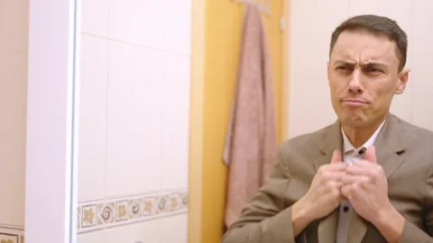 Businessman dressing up and checking himself in bathroom mirror Stock Footage 311306216