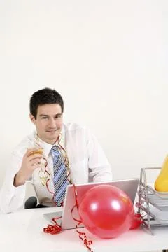 Businessman drinking champagne while using laptop Stock Photos
