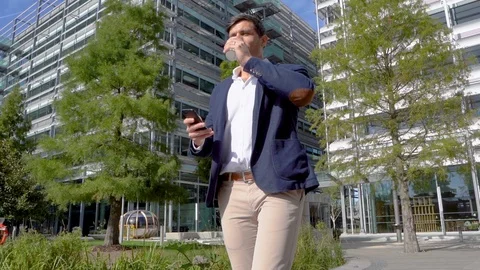 Businessman drinking coffee and using phone in slow motion Stock Footage 96050279