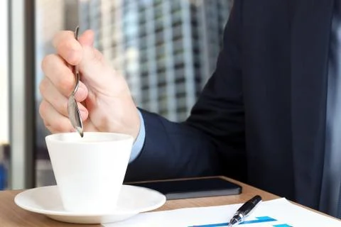 Businessman drinking coffee  and using the  mobile  smart  phone. Stock Photos