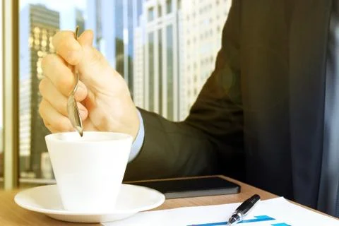 Businessman drinking coffee  and using the  mobile  smart  phone. Stock Photos
