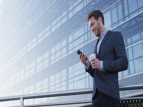 Businessman drinking coffee using mobile cell phone app Stock Footage 75052287