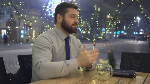 Businessman drinking hot warming drink and has stomach ache, at night in cafe Vidéo 72998568