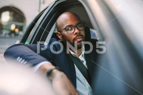 Businessman driving a car in city Stock Photos