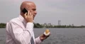 Businessman Eat Unhealthy Fast Food Person Talk Cell Phone Lunch Break Lake Side 4k or 4k+ Resolution