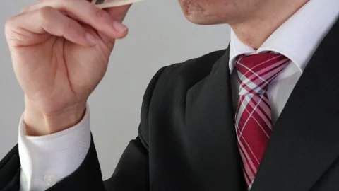 Businessman eating banknotes Stock Footage 325689913