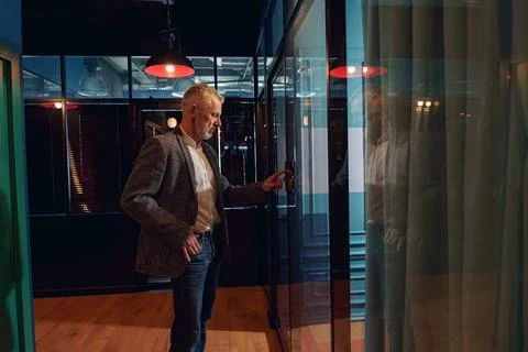 Businessman enters password lock code on alarm panel in office door for entering Foto stock