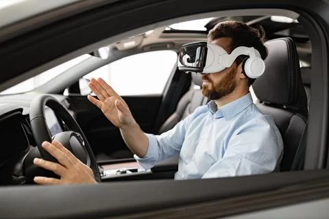 Businessman experiencing virtual reality inside car with VR headset Stock Photos