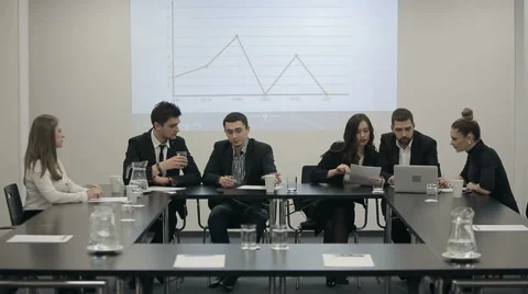 Businessman explaining bar chart to colleagues in a conference room Stock Footage 58194017
