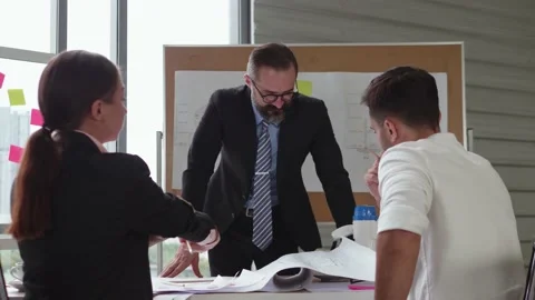 A businessman is explaining construction plan projects training a business team. Stock Footage 140033560