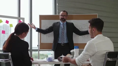 A businessman is explaining construction plan projects traning a business team. Video stock 140033599