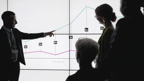 Businessman explaining data on a digital wall in a dark office Stock Footage 138983600