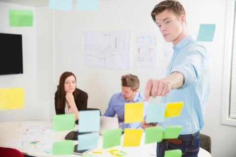 Businessman Explaining Notes To Colleagues In Office Stock Photos