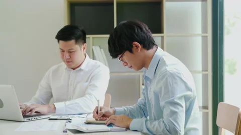 Businessman explaining numeric graphs on computer to colleagues. 库存影片 167247978