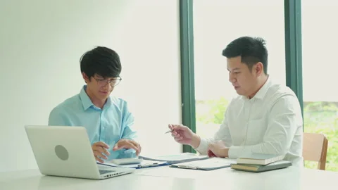 Businessman explaining numeric graphs on computer to colleagues. 库存影片 167248093