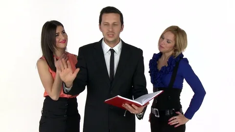 Businessman explaining a plan while two female are laughing behind his back Stockbeeldmateriaal 79434002