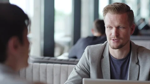Businessman explaining points to colleague in cafe Stock Footage 111758253