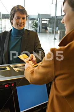 Businessman With A Female Check-In Attendant At An Airport Check-In Counter