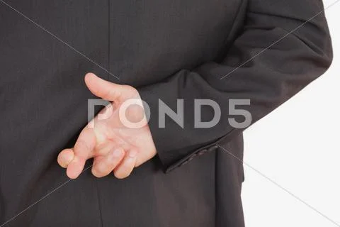 Businessman with fingers crossed Stock Photos