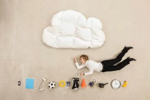 Businessman flying between cloud shape pillow and variety of items Stock Photos