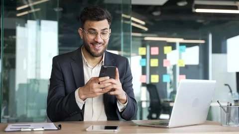 Businessman in a formal suit is using browsing mobile phone while sitting Stock Footage 319774978