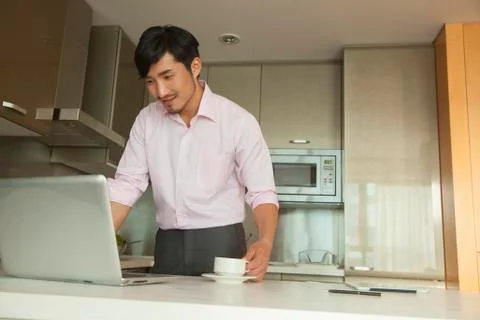 Businessman in front of his computer drinking coffee at home Stock Photos