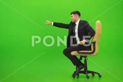 The businessman fun on the chair on the green background Stock Photos