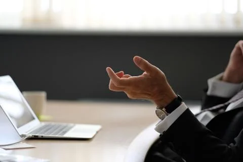 Businessman gesturing with his hands while talking on the phone in the office Stock Photos