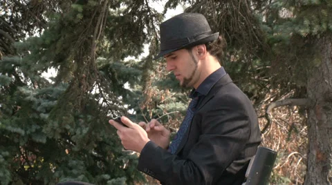 Businessman gesturing on touchscreen smartphone in the park Stock Footage 36995875