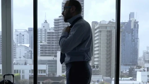 Businessman getting ready for work in his hotel room and ties a tie  Stock Footage 93231780