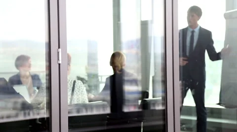 Businessman giving presentation using flipchart behind glass wall Stock Footage 59544251