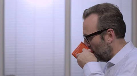 Businessman with glasses drinking coffee in the office Stock-Footage 68614583
