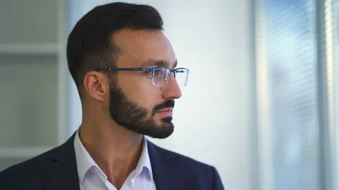 The businessman in glasses looking to the window through blinds Stock Footage 100743671