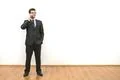 The businessman with glasses phones on the white wall background Photo