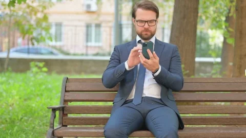 Businessman in Glasses Using Smartphone while Sitting Outdoor Video stock 282429739