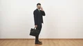 The businessman in glasses walking with a bag on the white wall background 4k or 4k+ Resolution