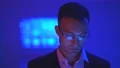 The businessman in glasses working on the blue background 4k or 4k+ Resolution