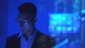 The businessman in glasses working in the dark room on the hologram background 4k or 4k+ Resolution