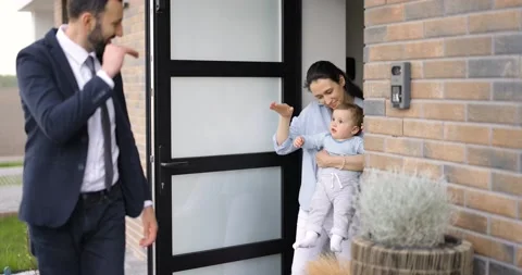 Businessman going out at work saying goodbye to his family at the doorway Stock Footage 154648460