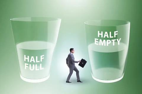 Businessman in half empty half full glass concept Stock Photos