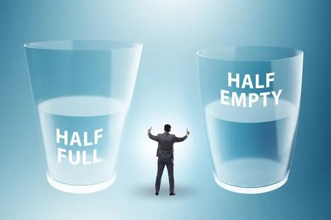 Businessman in half empty half full glass concept Stock Photos