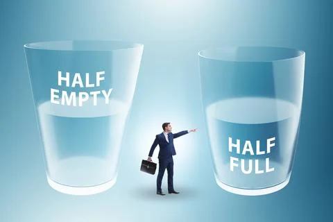 Businessman in half empty half full glass concept Stock Photos
